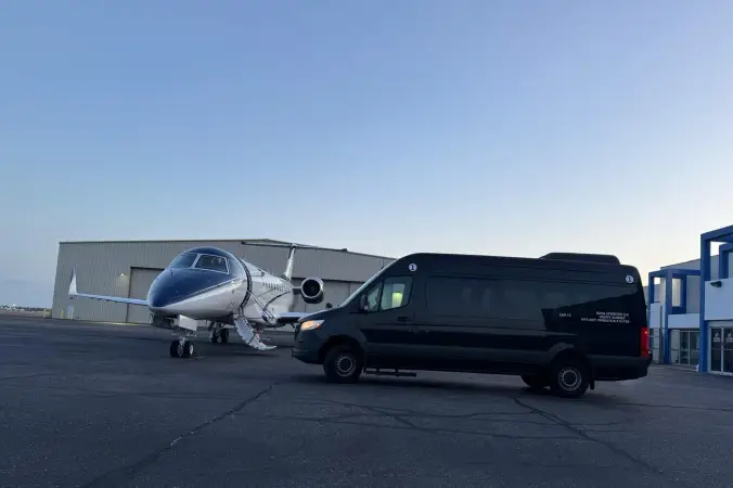 Sprinter van and private jet on the tarmac at twilight